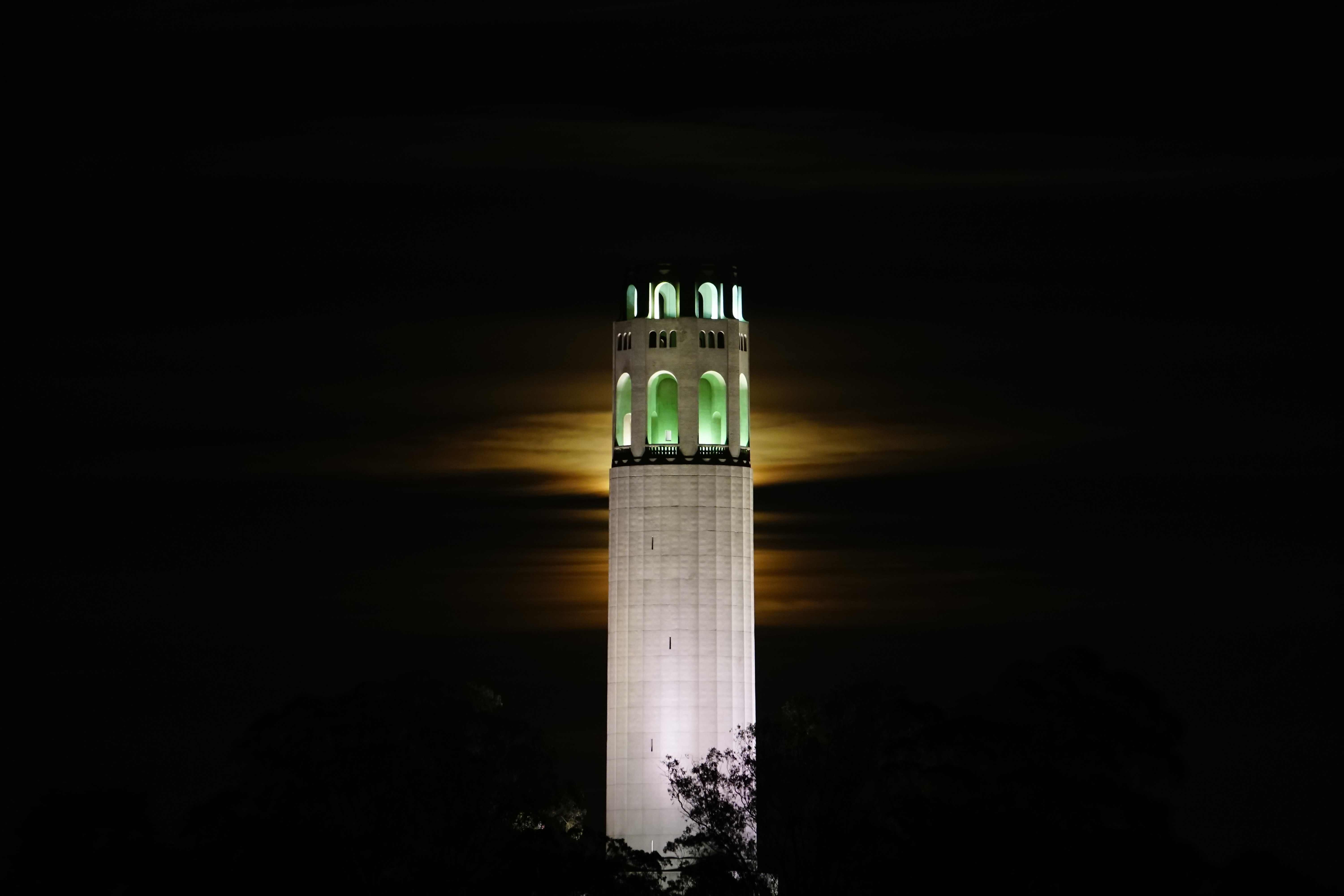 moon rises behind Coit Tower in San Francisco